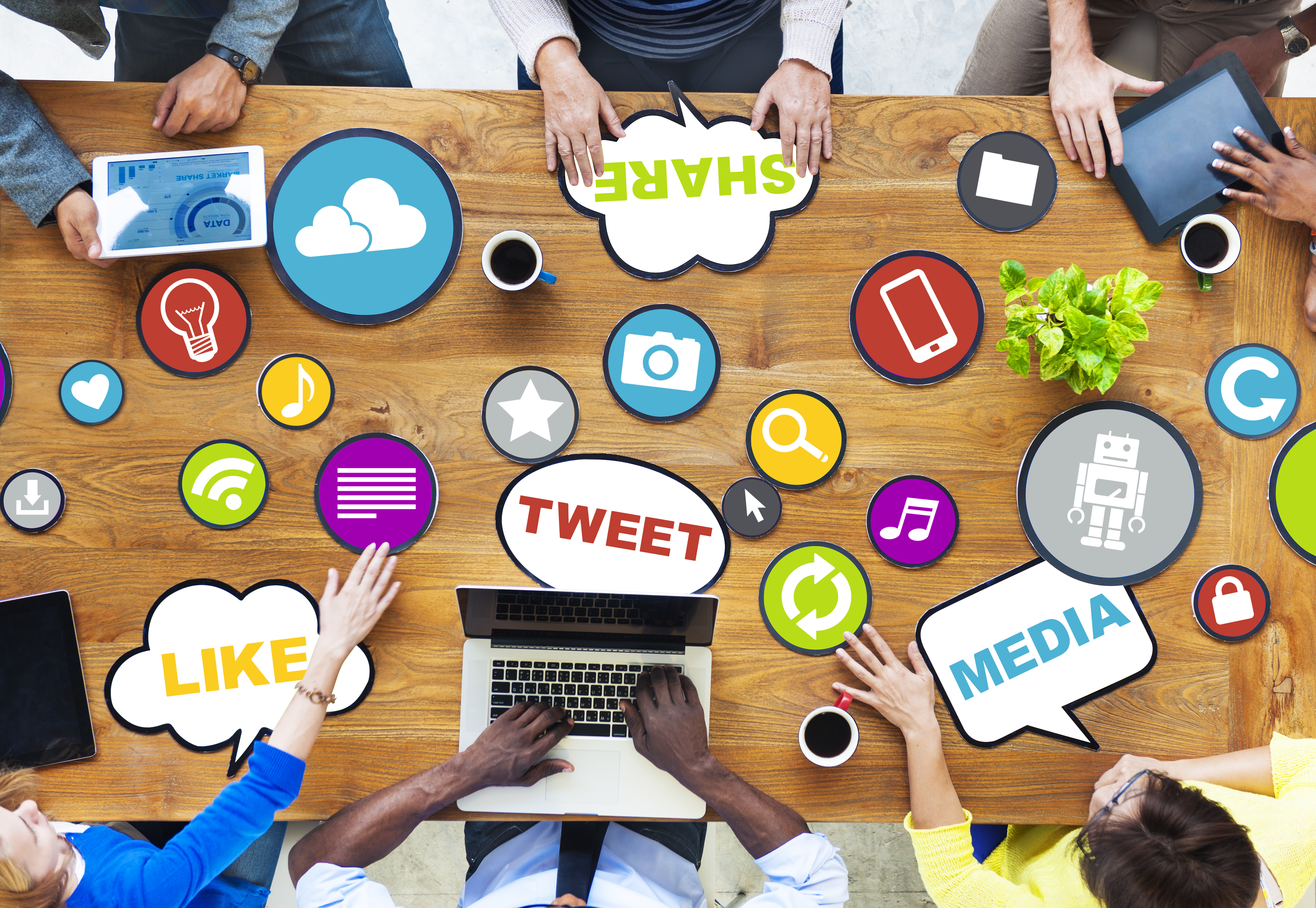 a lot of social media related icons on a wood table with words such as 'Tweet', 'Share', 'Like', and 'Media' displayed